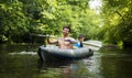 Young guys in boat with oars on river against background of green trees over water. Kayakers in kayak Royalty Free Stock Photo