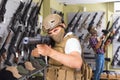 Young guys in military equipment with rifle in airsoft shop