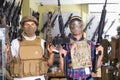 Young guys in military equipment with rifle in airsoft shop