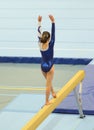 Young gymnast girl performing routine on balance beam Royalty Free Stock Photo