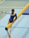 Young gymnast girl performing routine on balance beam Royalty Free Stock Photo