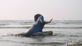 Young gymnast woman doing handspring on sandy beach