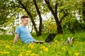 Young gyu freelincer at work on a laptop on a green grass and trees background Royalty Free Stock Photo