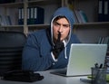 Young hacker hacking into computer at night Royalty Free Stock Photo