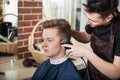 Young hairdresser trim hair to client in barber shop Royalty Free Stock Photo