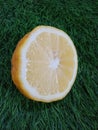 a young, halved lemon is yellow on the grass. Royalty Free Stock Photo