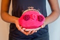 Young hand holds small pink purse with fuchsia flowers made in c