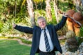 Young handicapped musician raising arms with violin.