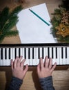 Young hands of a girl playing on a keyboard with Christmas decor Royalty Free Stock Photo