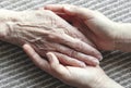 Young hands holding old woman palm