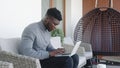 Young handsom black man working on the laptop on his balcony while drinking coffee Royalty Free Stock Photo