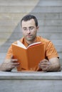 Young handsome adult reading a book