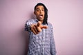 Young handsome african american afro man with dreadlocks wearing casual shirt pointing displeased and frustrated to the camera, Royalty Free Stock Photo