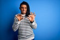 Young handsome african american afro man with dreadlocks wearing casual striped sweater disgusted expression, displeased and Royalty Free Stock Photo