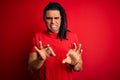 Young handsome african american afro man with dreadlocks wearing red casual t-shirt disgusted expression, displeased and fearful Royalty Free Stock Photo