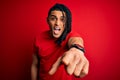 Young handsome african american afro man with dreadlocks wearing red casual t-shirt pointing displeased and frustrated to the Royalty Free Stock Photo