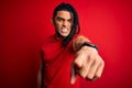 Young handsome african american afro man with dreadlocks wearing red casual t-shirt pointing displeased and frustrated to the Royalty Free Stock Photo