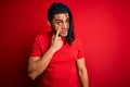 Young handsome african american afro man with dreadlocks wearing red casual t-shirt Pointing to the eye watching you gesture, Royalty Free Stock Photo