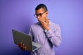 Young handsome african american business man working using laptop over purple background cover mouth with hand shocked with shame Royalty Free Stock Photo
