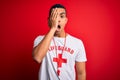 Young handsome african american lifeguard man wearing t-shirt with red cross and whistle Yawning tired covering half face, eye and Royalty Free Stock Photo