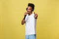 Young handsome African American Male Singer Performing with Microphone. Isolated over yellow gold background. Royalty Free Stock Photo