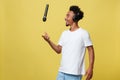 Young handsome African American Male Singer Performing with Microphone. Isolated over yellow gold background. Royalty Free Stock Photo