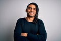 Young handsome african american man with dreadlocks wearing black casual sweater happy face smiling with crossed arms looking at Royalty Free Stock Photo