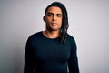 Young handsome african american man with dreadlocks wearing black casual sweater with serious expression on face Royalty Free Stock Photo