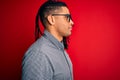 Young handsome african american man with dreadlocks wearing casual shirt and glasses looking to side, relax profile pose with Royalty Free Stock Photo