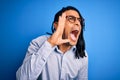 Young handsome african american man with dreadlocks wearing casual shirt and glasses shouting and screaming loud to side with hand Royalty Free Stock Photo