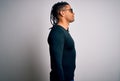 Young handsome african american man with dreadlocks wearing casual t-shirt and glasses looking to side, relax profile pose with Royalty Free Stock Photo