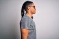 Young handsome african american man with dreadlocks wearing striped t-shirt and glasses looking to side, relax profile pose with Royalty Free Stock Photo