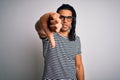 Young handsome african american man with dreadlocks wearing striped t-shirt and glasses looking unhappy and angry showing Royalty Free Stock Photo