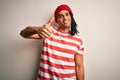 Young handsome african american man with dreadlocks wearing striped t-shirt and wool hat doing happy thumbs up gesture with hand Royalty Free Stock Photo