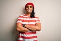 Young handsome african american man with dreadlocks wearing striped t-shirt and wool hat happy face smiling with crossed arms Royalty Free Stock Photo