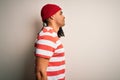 Young handsome african american man with dreadlocks wearing striped t-shirt and wool hat looking to side, relax profile pose with Royalty Free Stock Photo