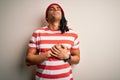 Young handsome african american man with dreadlocks wearing striped t-shirt and wool hat smiling with hands on chest with closed Royalty Free Stock Photo