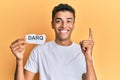 Young handsome african american man holding darq technologies word smiling with an idea or question pointing finger with happy