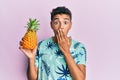 Young handsome african american man holding pineapple covering mouth with hand, shocked and afraid for mistake Royalty Free Stock Photo