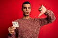 Young handsome african american man holding reminder paper with yes message with angry face, negative sign showing dislike with