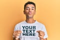 Young handsome african american man holding your text here banner looking at the camera blowing a kiss being lovely and sexy
