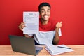 Young handsome african american man showing a passed exam screaming proud, celebrating victory and success very excited with Royalty Free Stock Photo