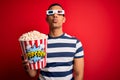 Young handsome african american man watching movie using 3d glasses eating popcorns making fish face with lips, crazy and comical Royalty Free Stock Photo