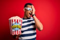 Young handsome african american man watching movie using 3d glasses eating popcorns Yawning tired covering half face, eye and Royalty Free Stock Photo