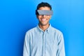 Young handsome african american man wearing banner glasses covering eyes looking positive and happy standing and smiling with a