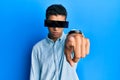 Young handsome african american man wearing banner glasses covering eyes pointing with finger to the camera and to you, confident