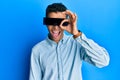 Young handsome african american man wearing banner glasses covering eyes smiling happy doing ok sign with hand on eye looking