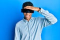 Young handsome african american man wearing banner glasses covering eyes stressed and frustrated with hand on head, surprised and