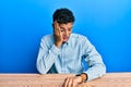 Young handsome african american man wearing casual clothes sitting on the table looking at the watch time worried, afraid of Royalty Free Stock Photo