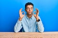 Young handsome african american man wearing casual clothes sitting on the table relaxed and smiling with eyes closed doing Royalty Free Stock Photo